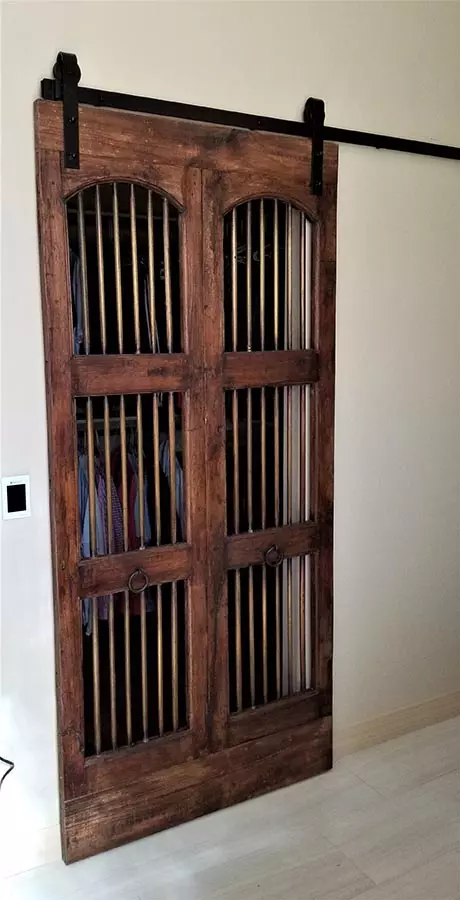 A wooden door with bars on the side of it.